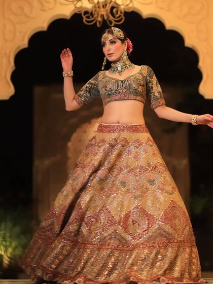 A graceful pose by the bride, highlighting the flow of her lehenga and the elegance of her choker.