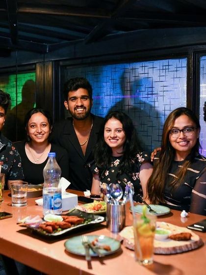 Good food, good drinks, and good music. A group enjoying a full night out at their table.