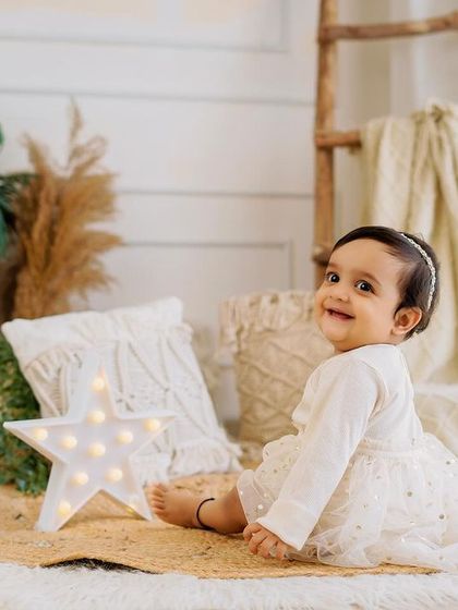 A sweet glance over the shoulder. This boho-chic setup with neutral tones, plants, and soft textures creates a calm and beautiful portrait.