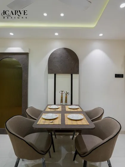An elegant four-seater dining setup. The design uses arched motifs on the wall to create a sense of height and sophistication, while the comfortable upholstered chairs invite long conversations over meals.