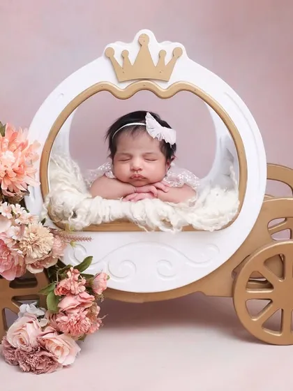 A princess in her pumpkin carriage. This fairytale-inspired prop is perfect for a magical newborn session. The soft fur lining and floral details create a dreamy and comfortable spot for your sleeping baby.