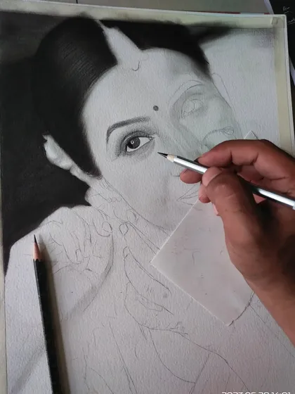 Here I am working on the shading of a portrait. I use a small piece of paper under my hand to avoid smudging the graphite as I carefully add layers of tone and detail.