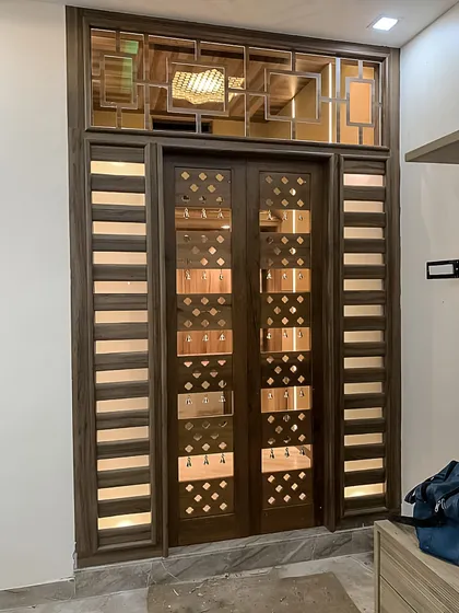 The entrance to a pooja room is just as important as the space within. Here, we designed a set of ornate wooden doors with custom metal jaali work and translucent panels. The entire door frame is backlit, creating a grand and welcoming threshold that sets a sacred tone before you even step inside.