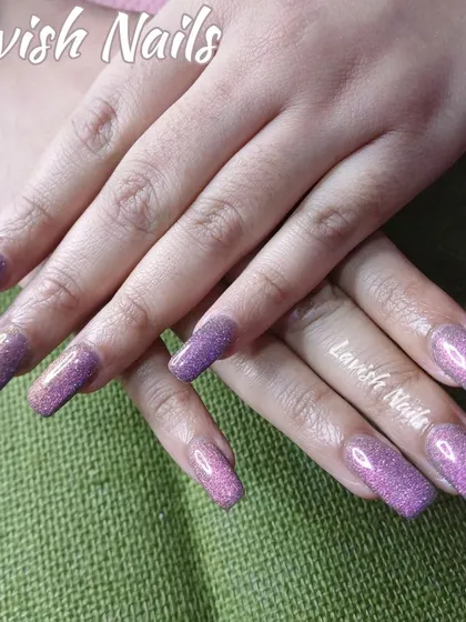 Long square nails with a beautiful purple holographic glitter finish.