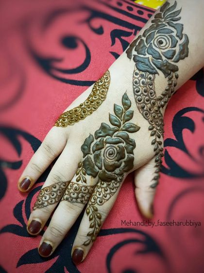 A Khafif-style back-hand henna with bold roses and delicate, trailing vines.