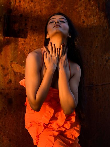 An expressive and dramatic pose, with the model's neck elongated towards the sun. The warm light creates a beautiful glow on her skin.