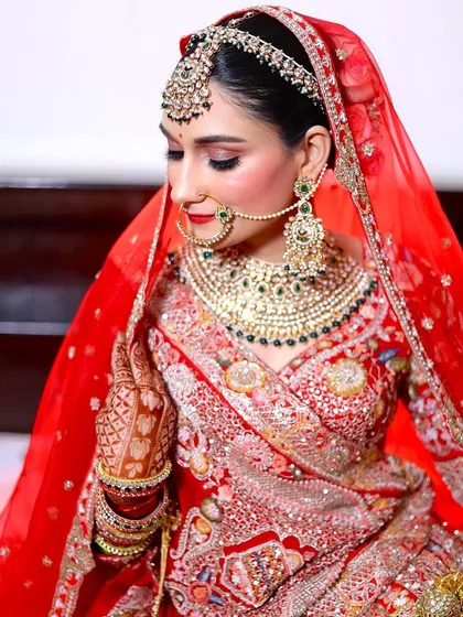 A close-up of this bride in red. Her soft makeup and beautiful green jewellery create a stunning contrast.