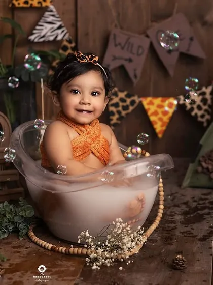 Bubbles, smiles, and a wild jungle theme. This bath session is full of fun details, from the animal print banner to the little tiger friends watching over her.