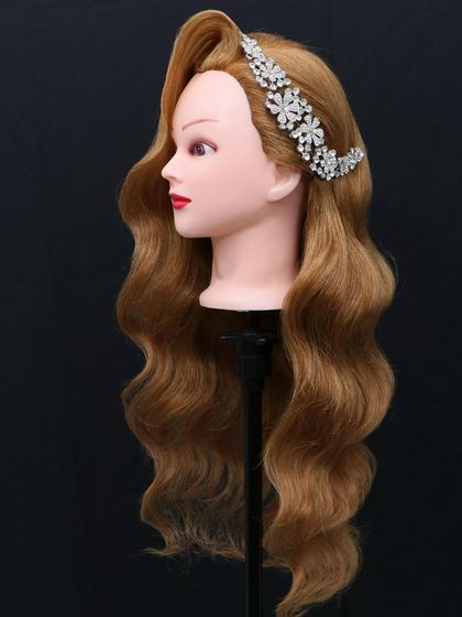 Classic Hollywood waves on a mannequin, demonstrating the perfect S-curve pattern that students learn to master.