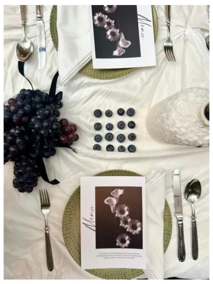 An overhead view of the plum and grape themed table setting, with custom menus and scattered blueberries.