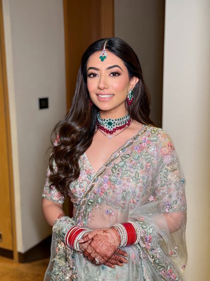 The bride is all smiles, ready for her reception. The makeup is designed to look great both in person and in photographs.