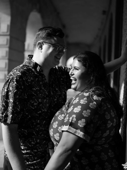A black and white shot capturing a burst of laughter, highlighting the genuine fun and happiness of the couple's interaction.