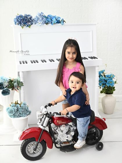 Big sister proudly helps her little brother on his first bike ride. Capturing the bond between siblings is one of the most heartwarming parts of a family milestone session.