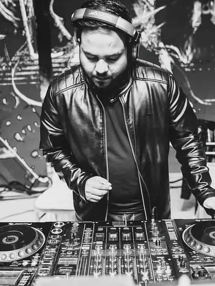An artistic shot of me mixing at a gig. I am deeply involved in the technical side of DJing, ensuring every transition is smooth and every beat drop has maximum impact.