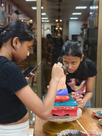 Teamwork and concentration in our Ganpati workshop. Students collaborate and learn from each other as they meticulously paint and decorate their clay idols, preparing them for the festival.