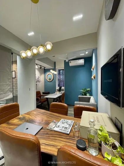 A view of our conference room, with its live-edge wooden table and a bold blue accent wall. It's a professional yet inspiring environment for our client meetings and team discussions.
