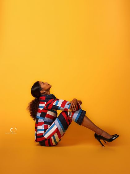 A contemplative pose on the floor, looking up. The use of negative space is powerful, creating a feeling of hope or aspiration.