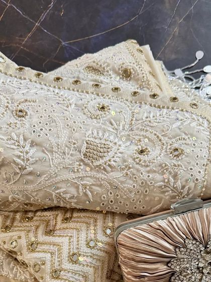 A close-up of the folded saree with a clutch, perfect for appreciating the intricate details.