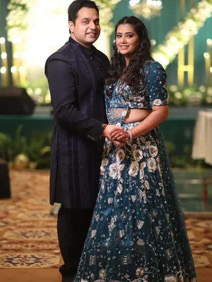 A classic portrait of the couple, hand in hand, ready to celebrate their Sangeet night in a beautifully decorated venue.
