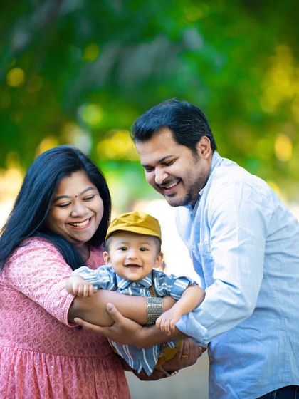 A playful and loving family moment captured outdoors. The genuine smiles and laughter make this a truly heartwarming portrait.