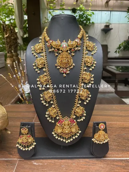 An elegant temple jewellery set with a long, delicate haram and a matching choker. The design features Lakshmi pendants and is finished with pearls.