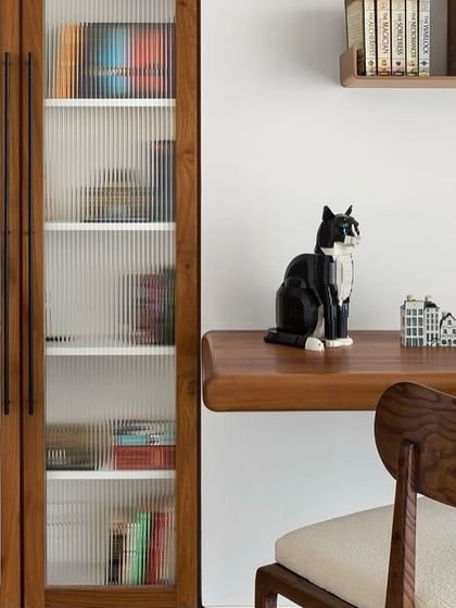 A close-up of the study area in the West Coast Residence. The floating teak desk and fluted glass bookcase doors are examples of our pet-friendly and highly functional design approach.