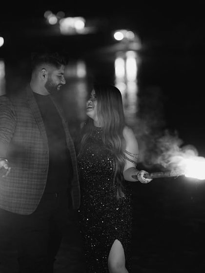 A creative black and white shot of the couple with fire props, adding a dramatic and edgy feel to their night pre-wedding shoot.