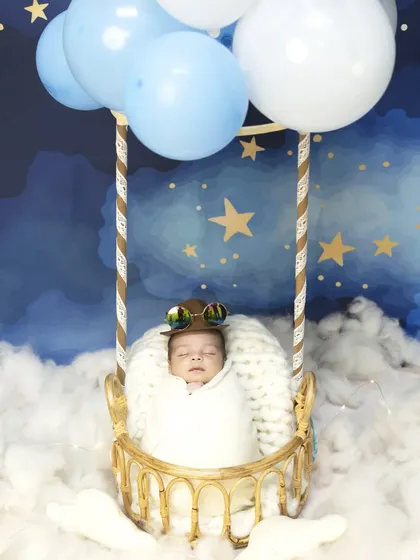 This variation of the hot air balloon theme features the baby wearing cute aviator goggles. It adds a touch of adventurous spirit to the whimsical and peaceful newborn portrait.
