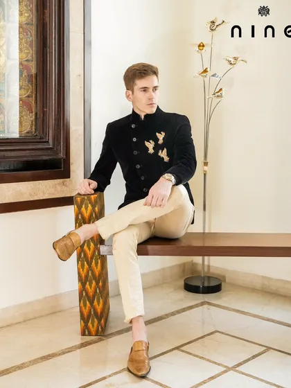 For weddings and receptions, we create Indo-Western outfits that stand out. This Angrakha-style Bandhgala in rich velvet is detailed with antique gold embroidered birds, blending heritage with contemporary elegance.