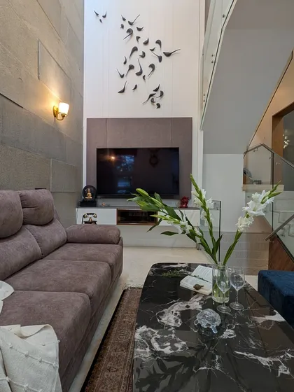 Even in compact areas, we believe in making a statement. This double-height living room uses a textured stone wall and a custom 3D bird sculpture to draw the eye upward, creating a feeling of spaciousness and unique character.