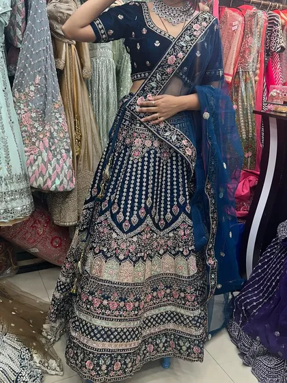 Another angle of the royal blue velvet lehenga, highlighting the detailed embroidery on the skirt and the sheer dupatta.
