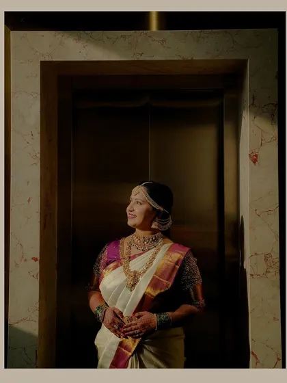 A beautifully lit portrait of the bride standing in an elevator, using the unique setting and dramatic shadows to create a sophisticated and modern bridal shot.