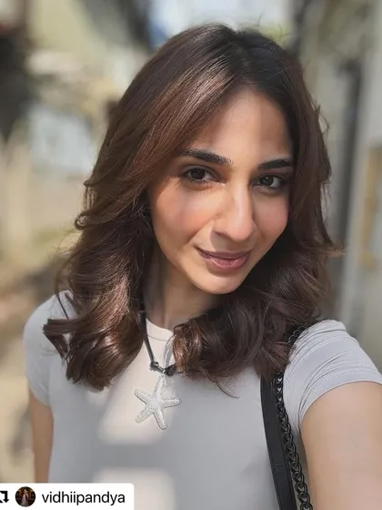 A beautiful, sunlit shot of this layered haircut. The natural light highlights the soft texture and shape of the cut perfectly.
