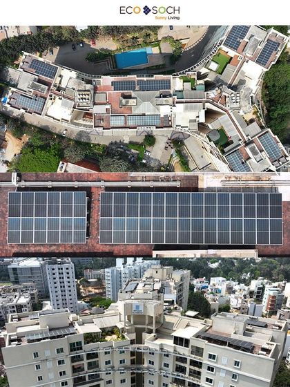 An overhead drone shot providing a clear layout of the solar panel grid on a residential complex, demonstrating the scope of the renewable energy project.