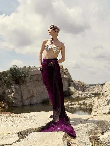 A full-length view of the 'Siren' concept, demonstrating how the makeup, hair, and styling come together to create a complete character against the dramatic backdrop.