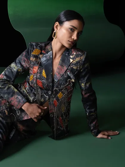 Another look from the Advait campaign, this time a full suit with intricate embellishments. The seated pose creates an elegant and grounded feel, contrasting with the vibrant energy of the other shots.