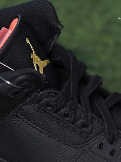 A detailed shot of the premium tumbled black leather and the gold Jumpman logo on the tongue of the Jordan 3 J Balvin 'Rio'.