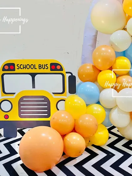The wheels on the bus go round and round. This cheerful school bus cutout was another fun element in the car and vehicle-themed birthday party, surrounded by a colorful balloon garland.