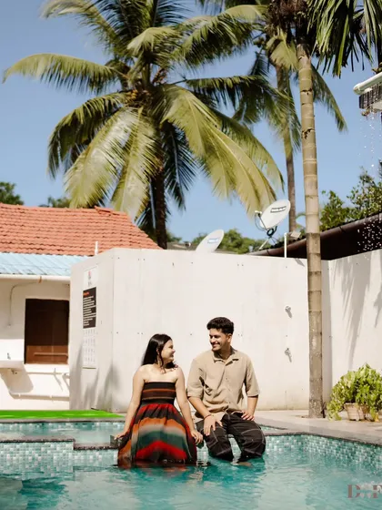 A beautiful, sunny shot of the couple by the pool, with palm trees framing the background. This image has a perfect vacation vibe for a relaxed pre-wedding shoot.