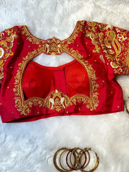 I love bringing symbolic designs to life, like the bird motifs on this classic red bridal blouse. This piece showcases detailed zardosi and French knot embroidery, a testament to the handwork that goes into every creation.