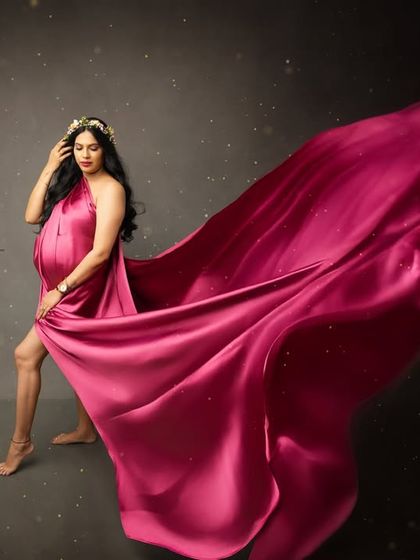 A dramatic flying fabric shot in a vibrant magenta gown. This pose captures a sense of freedom and power, celebrating the transformative journey of motherhood.