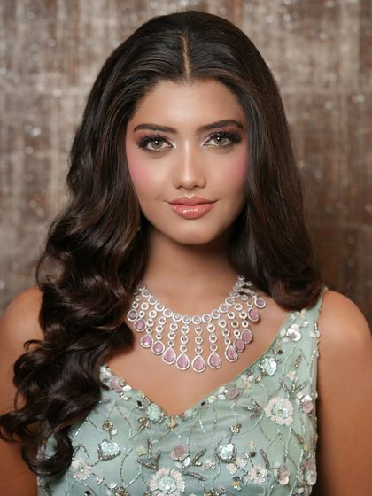 A close-up of the soft glam makeup. The focus is on radiant skin, subtly defined eyes, and glossy lips, creating a fresh and youthful look perfect for an evening event.