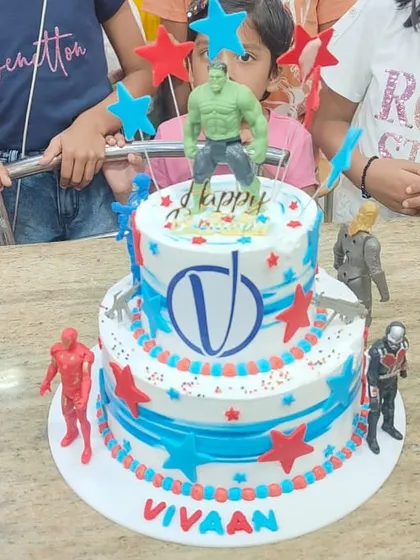 A fun two-tier Avengers cake with action figures, perfect for a young fan's party.
