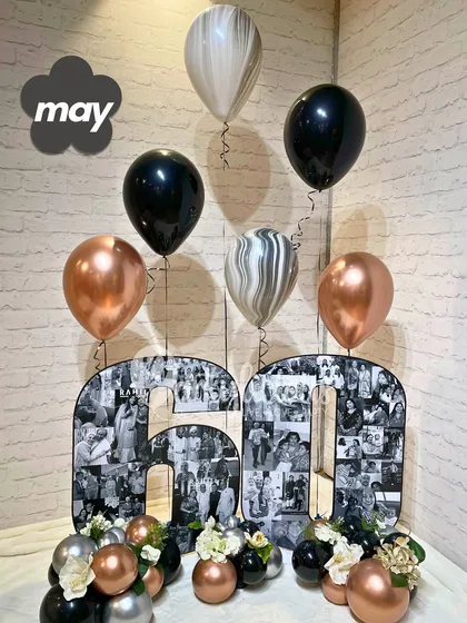 A sophisticated 60th birthday setup featuring custom photo collage numbers and a classic black, silver, and rose gold balloon bouquet.