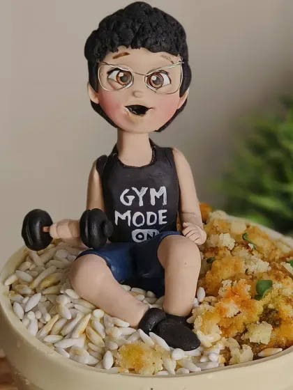 A close-up of the "Gym Mode" figurine, showing the detail on his face and the tiny dumbbell he's lifting.