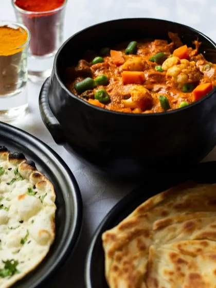 A classic North Indian meal featuring a hearty vegetable curry served with naan and paratha. The spices in the shot glasses are the secret to our authentic flavors.