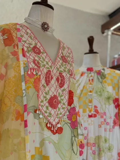 A close-up of the v-neck kurta, showing the intricate floral embroidery and playful tassel details that add a touch of charm.
