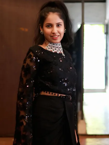 This elegant American Diamond choker with green stones is perfect for a cocktail party or reception. It pairs beautifully with this modern black saree.