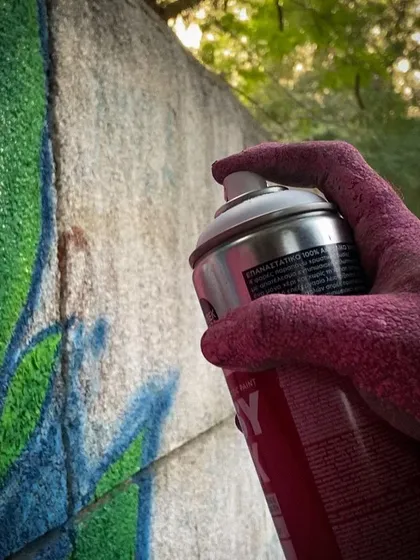 Here, I'm using a spray can to create a piece inspired by nature. This shows how I merge the rebellious energy of graffiti with the organic forms of the natural world, creating a unique harmony on the wall.