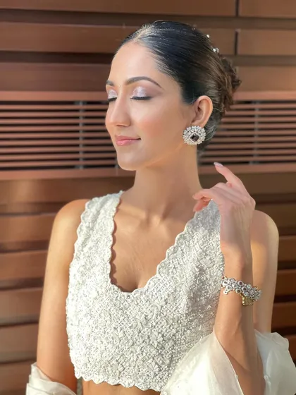 A serene portrait of a client with a sleek, pearl-adorned bun, showcasing a look that is both modern and timeless.
